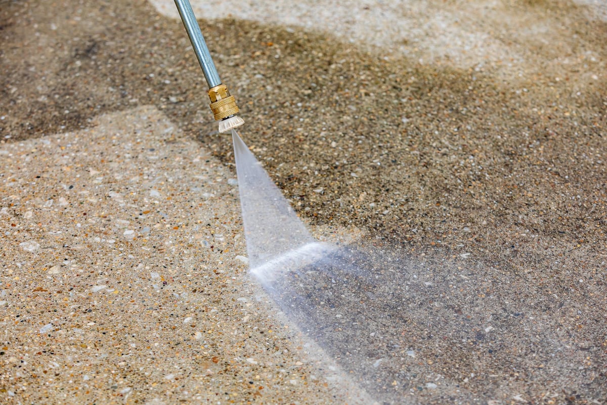 Freshly pressure-washed residential driveway with clean, restored concrete surface — demonstration image